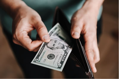 Description: Unrecognizable man holding wallet with money